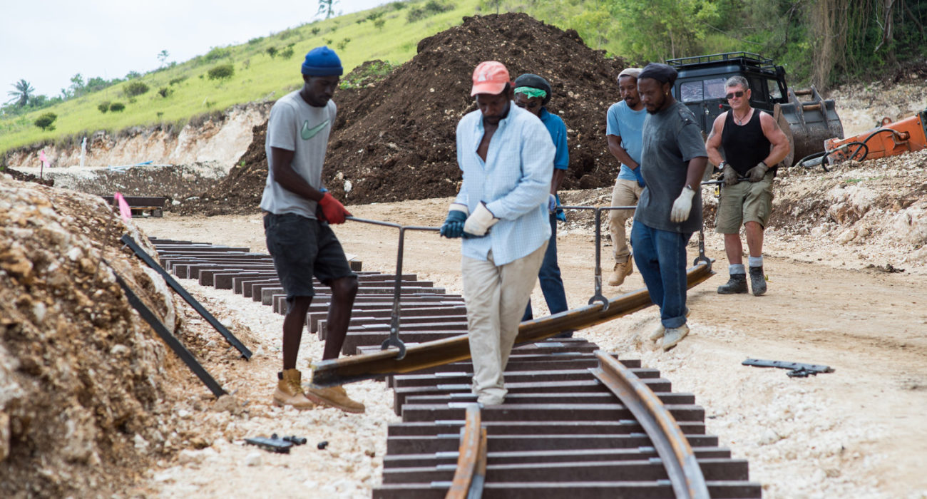 Track workers installing a length of rail. Photo by Sofie Warren.