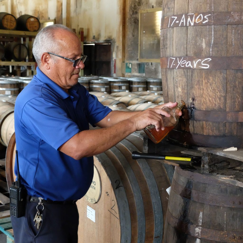 Noel García, who has worked in the cooperage at Destilería Serrallés for thirty-two years, samples some seventeen year old. Photo by Ben Schaffer.